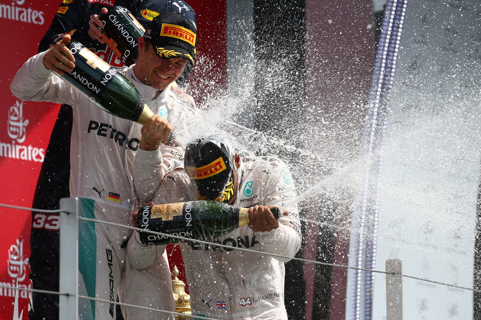 F1-coureurs Nico Rosberg en Lewis Hamilton spuiten met champagne